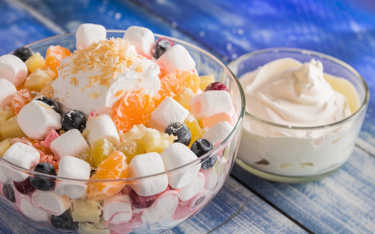 A vibrant Ambrosia Salad Recipe with marshmallows, fruits, and whipped cream.